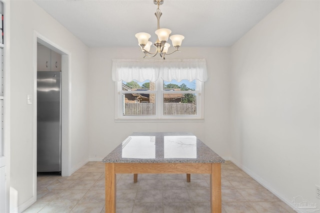 unfurnished dining area featuring light tile patterned floors and a notable chandelier