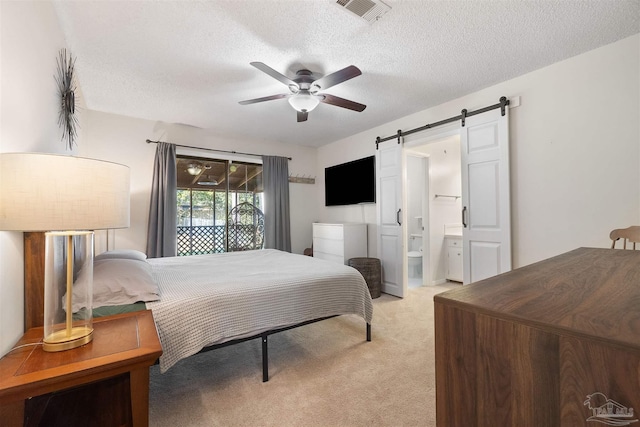 carpeted bedroom with ensuite bathroom, a textured ceiling, access to outside, ceiling fan, and a barn door