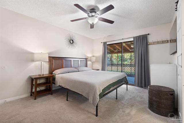 bedroom with a textured ceiling, access to outside, light colored carpet, and ceiling fan