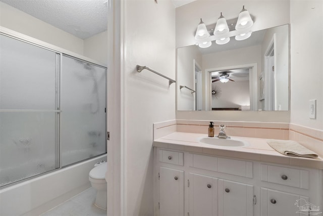 full bathroom with toilet, shower / bath combination with glass door, a textured ceiling, vanity, and ceiling fan