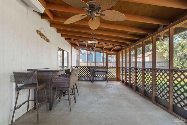 sunroom / solarium with beamed ceiling and ceiling fan