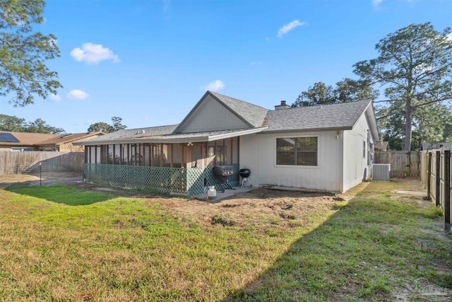 back of property with a sunroom, a yard, and central AC unit