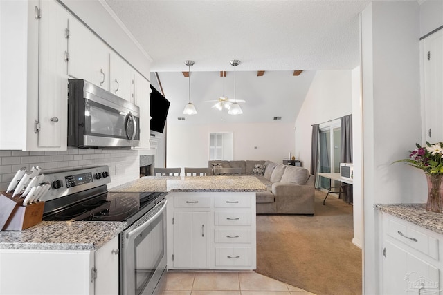 kitchen with stainless steel appliances, white cabinetry, and decorative light fixtures