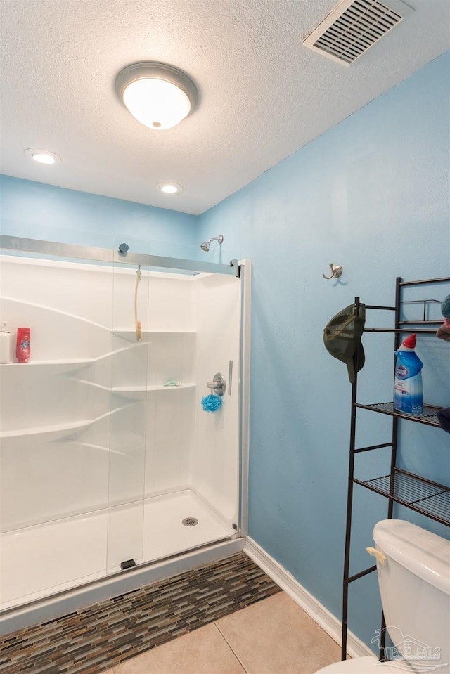 bathroom featuring walk in shower, toilet, and a textured ceiling