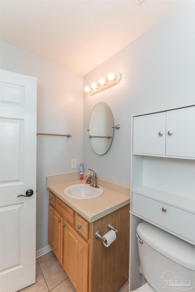 bathroom with vanity, tile patterned flooring, and toilet