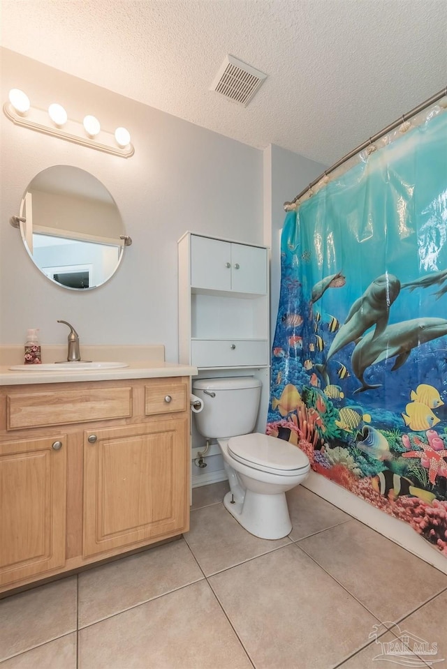 bathroom featuring tile patterned flooring, a shower with curtain, a textured ceiling, vanity, and toilet