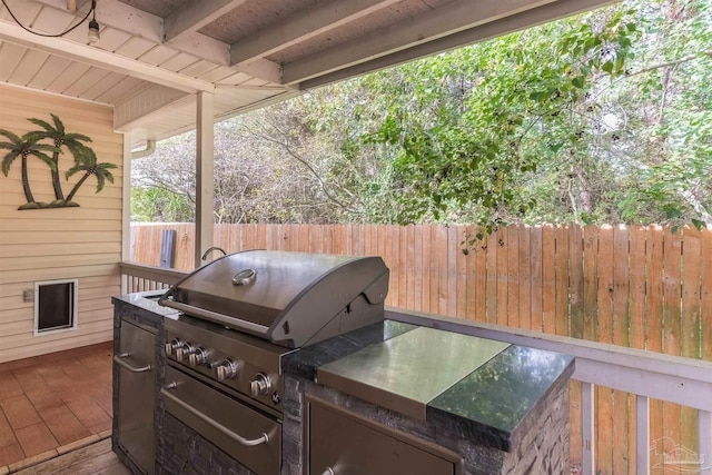 view of patio / terrace with a grill, a deck, and exterior kitchen