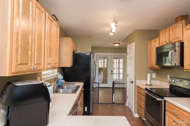 kitchen with french doors, appliances with stainless steel finishes, a textured ceiling, dark hardwood / wood-style floors, and sink