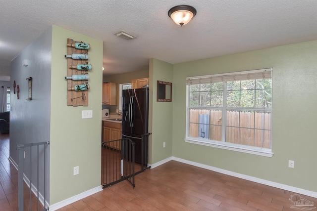 hall with a textured ceiling and hardwood / wood-style flooring