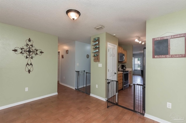 empty room featuring dark wood-type flooring and a textured ceiling