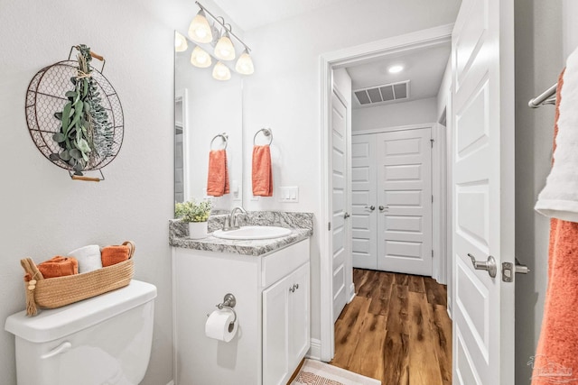 bathroom featuring vanity, toilet, and wood-type flooring