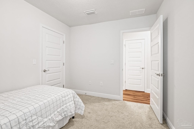 carpeted bedroom featuring a textured ceiling