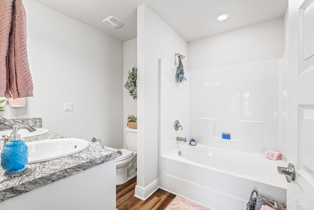 full bathroom with hardwood / wood-style flooring, vanity, toilet, and shower / tub combination