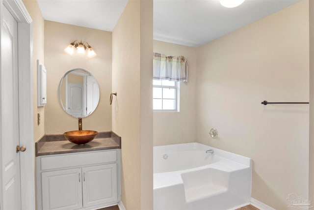 bathroom with a tub and vanity