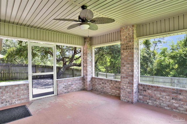 unfurnished sunroom featuring ceiling fan and a healthy amount of sunlight