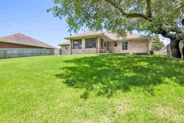 rear view of property with a lawn and central AC unit