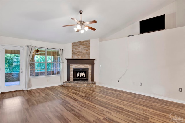 unfurnished living room featuring a stone fireplace, lofted ceiling, and hardwood / wood-style floors