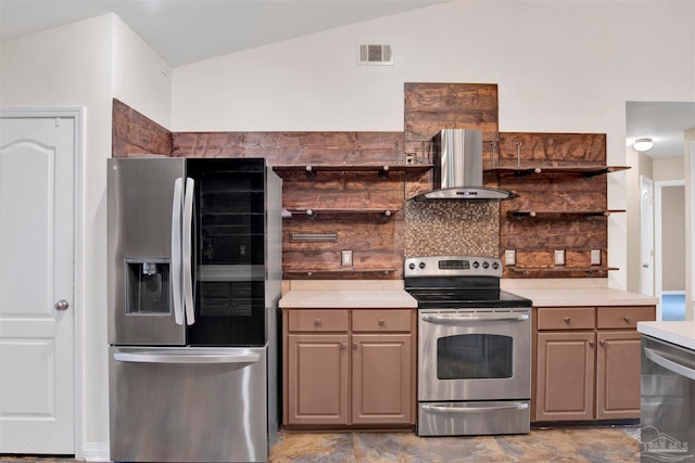 kitchen featuring appliances with stainless steel finishes, light tile patterned flooring, lofted ceiling, and wall chimney range hood