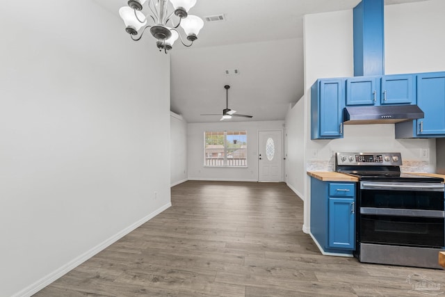 kitchen featuring butcher block counters, ceiling fan with notable chandelier, blue cabinetry, and range with two ovens