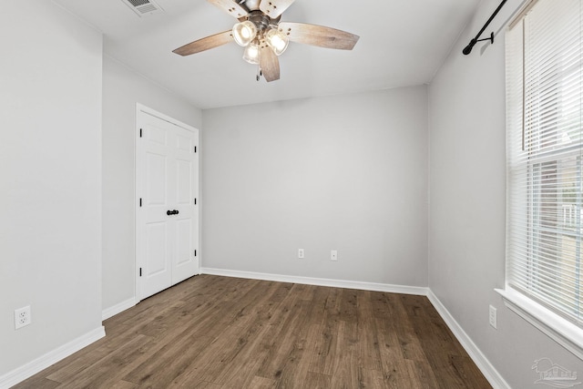 unfurnished room featuring dark wood-type flooring and ceiling fan