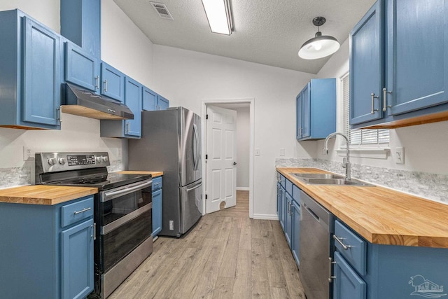 kitchen featuring butcher block countertops, blue cabinetry, and appliances with stainless steel finishes