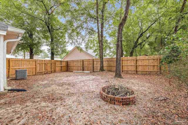 view of yard featuring cooling unit and an outdoor fire pit