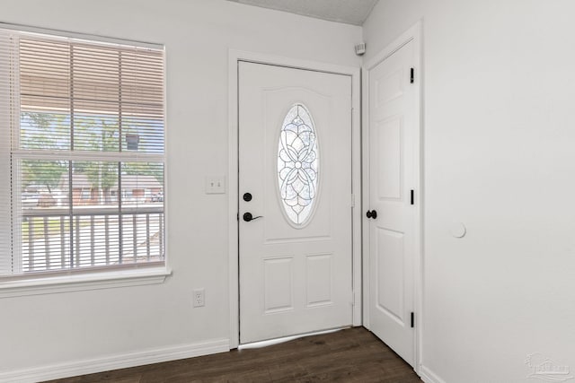 foyer entrance with dark hardwood / wood-style floors and a textured ceiling