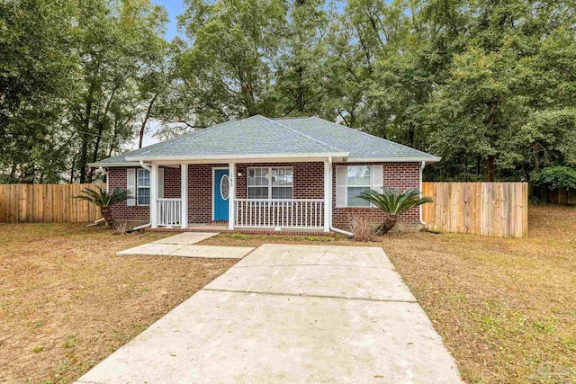 bungalow with covered porch and a front lawn