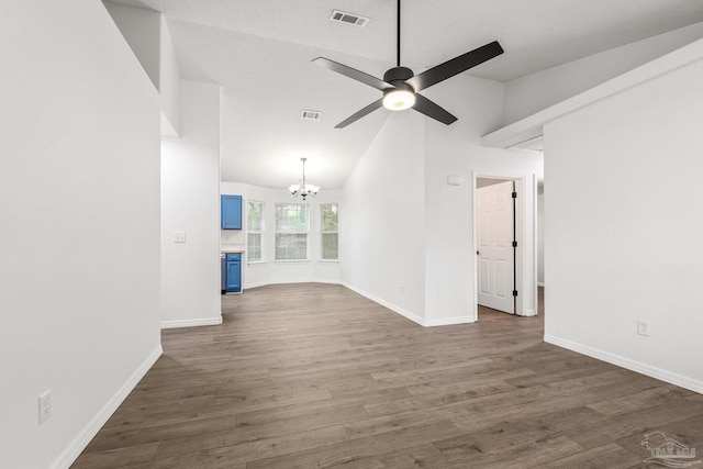 unfurnished living room featuring high vaulted ceiling, dark hardwood / wood-style flooring, and ceiling fan with notable chandelier