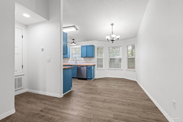 kitchen featuring dark hardwood / wood-style flooring, hanging light fixtures, dishwasher, and blue cabinets