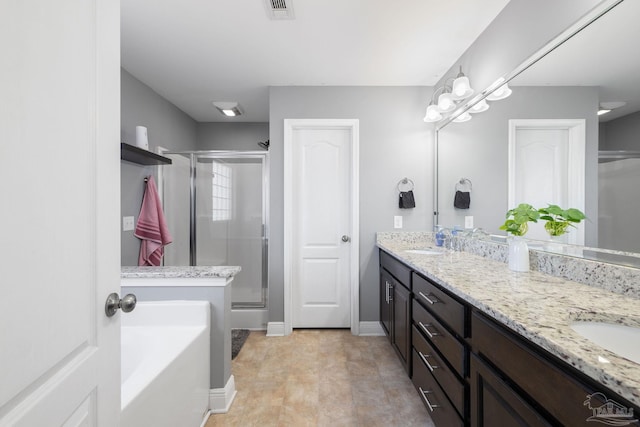 bathroom featuring double vanity, visible vents, a stall shower, and a sink