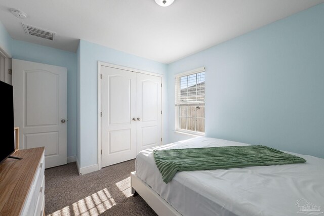 carpeted bedroom featuring visible vents, baseboards, and a closet