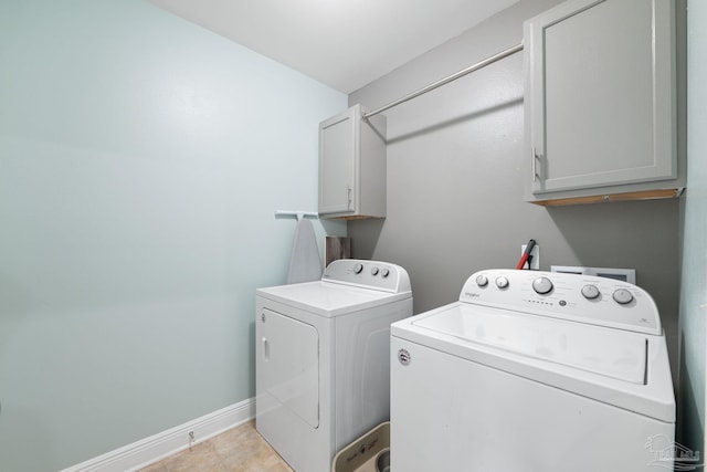 washroom featuring washer and dryer, baseboards, and cabinet space