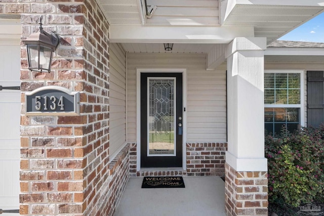 doorway to property featuring brick siding