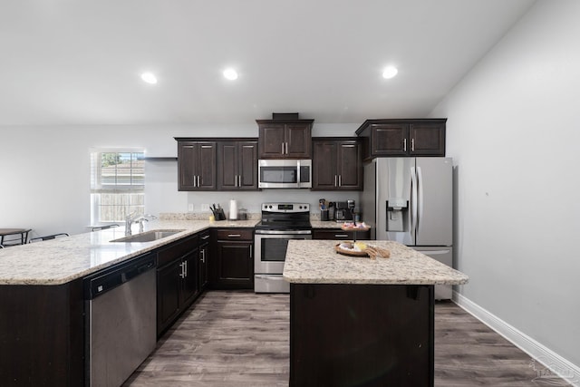 kitchen featuring dark wood-type flooring, a sink, a kitchen island, stainless steel appliances, and dark brown cabinets