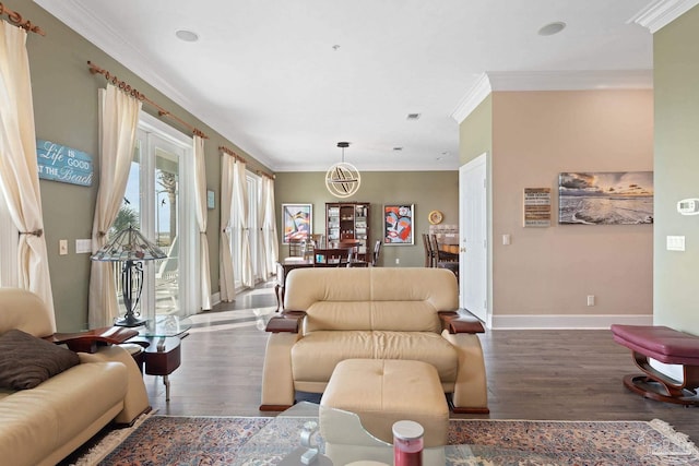 living area with crown molding, baseboards, and wood finished floors