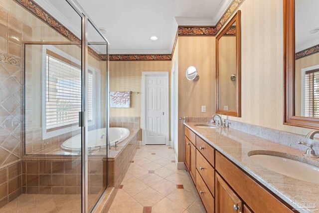 bathroom featuring a sink, a healthy amount of sunlight, a garden tub, and wallpapered walls