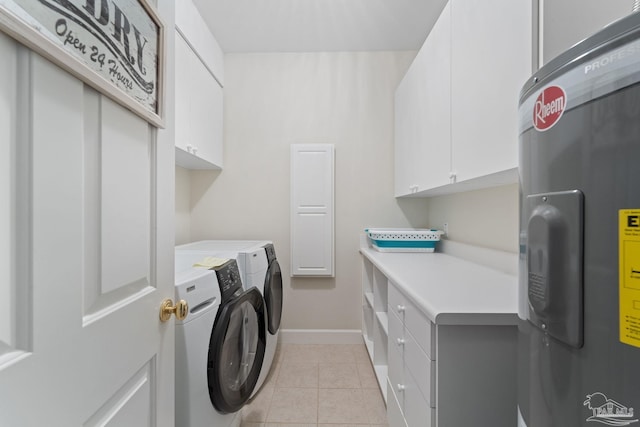 clothes washing area with cabinet space, electric water heater, light tile patterned flooring, independent washer and dryer, and baseboards