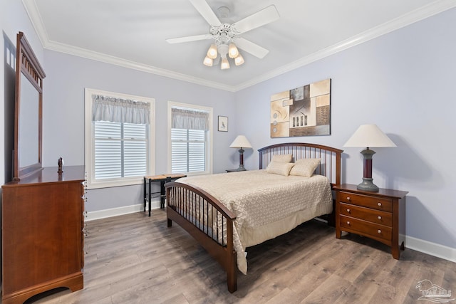 bedroom with baseboards, ceiling fan, wood finished floors, and crown molding