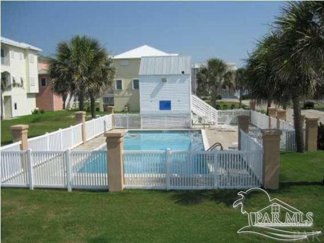 community pool with a yard and fence