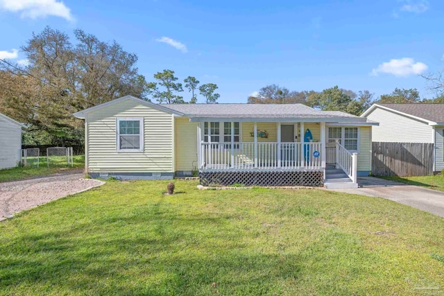 ranch-style home with driveway, a front lawn, a porch, fence, and crawl space