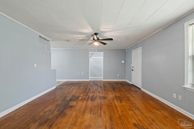 spare room featuring ceiling fan, baseboards, hardwood / wood-style floors, and crown molding