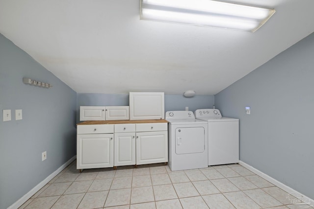 washroom with baseboards, cabinet space, light tile patterned flooring, and washer and clothes dryer