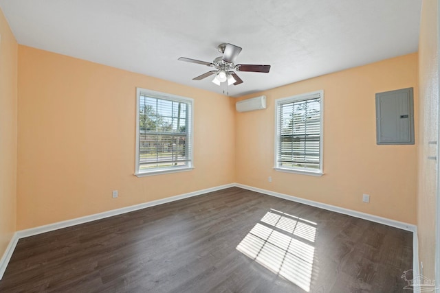 empty room featuring a ceiling fan, baseboards, electric panel, dark wood-type flooring, and a wall mounted air conditioner