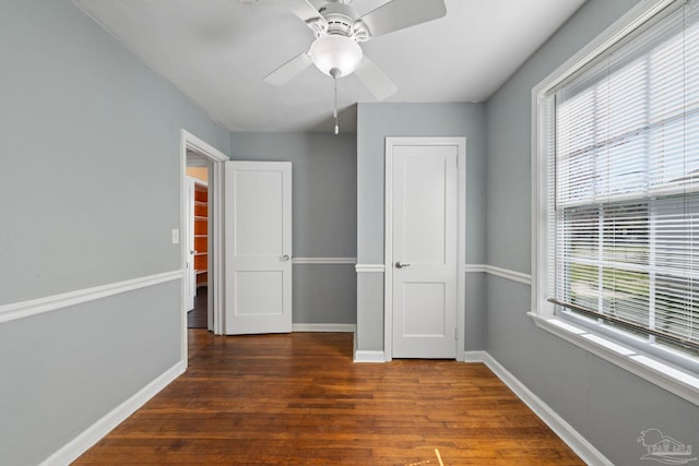 unfurnished bedroom featuring baseboards, wood finished floors, and a ceiling fan