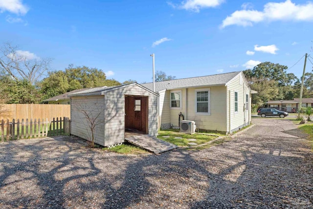 exterior space with a storage unit, an outdoor structure, and fence