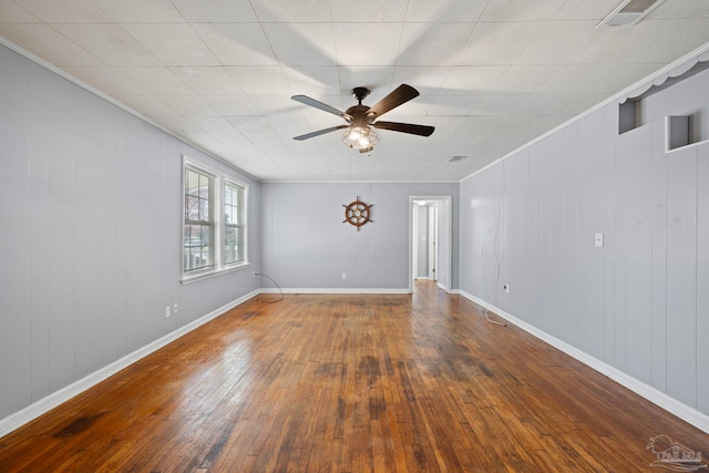 spare room featuring hardwood / wood-style flooring, baseboards, visible vents, and ornamental molding