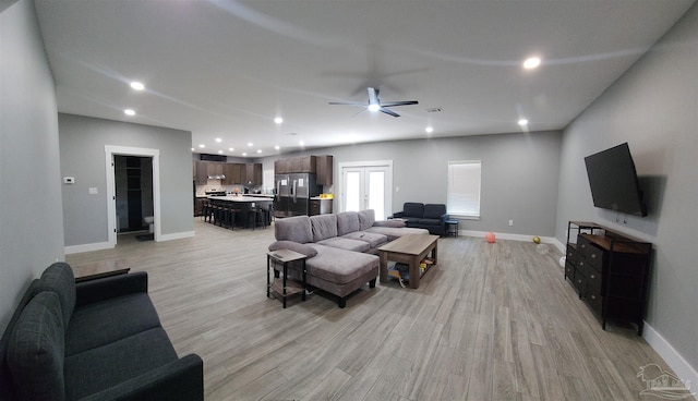 living room featuring ceiling fan and light hardwood / wood-style flooring