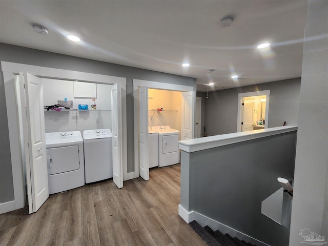 washroom featuring washer and clothes dryer and light hardwood / wood-style floors