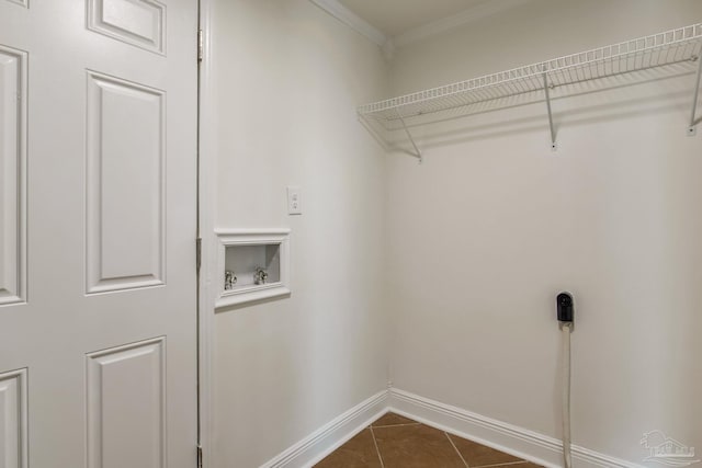 washroom featuring washer hookup, crown molding, and dark tile patterned floors